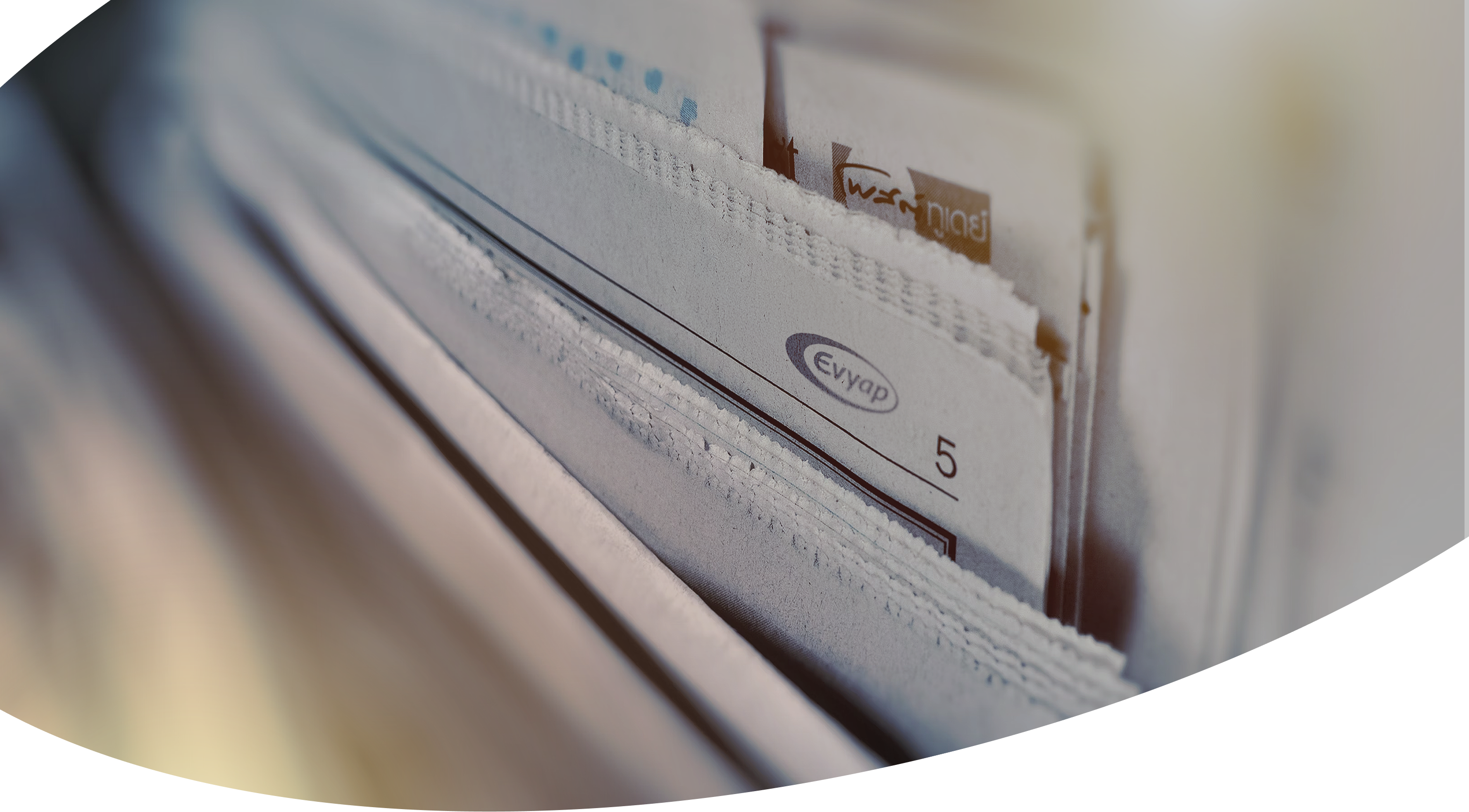 Stacked newspapers with Evyap branding